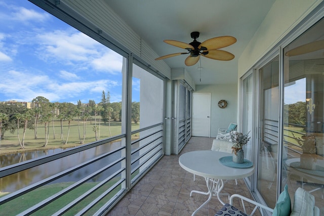 sunroom featuring a water view and ceiling fan