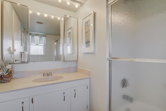 bathroom featuring vanity and an enclosed shower