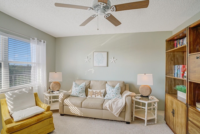 carpeted living room with ceiling fan and a textured ceiling