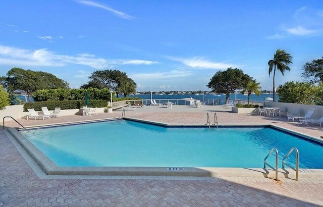 view of pool featuring a patio area and a water view