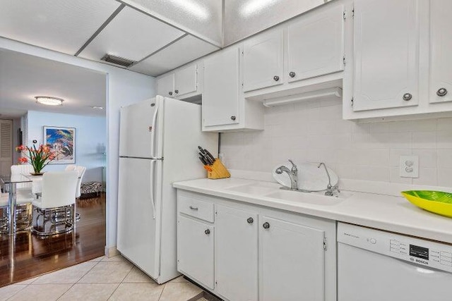 kitchen featuring white cabinetry and white appliances