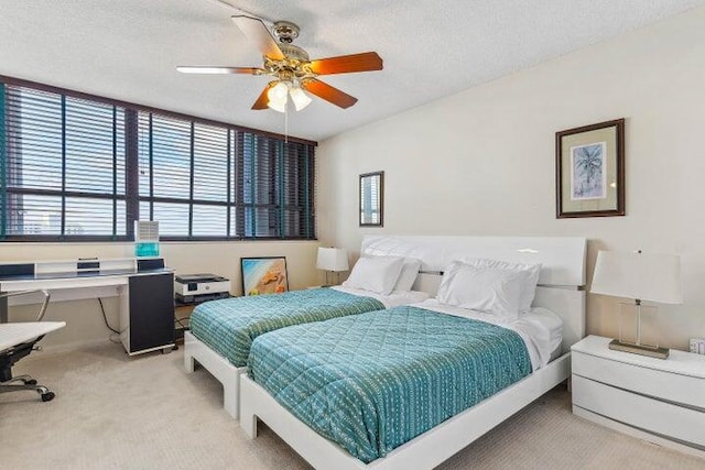 carpeted bedroom featuring a textured ceiling and ceiling fan