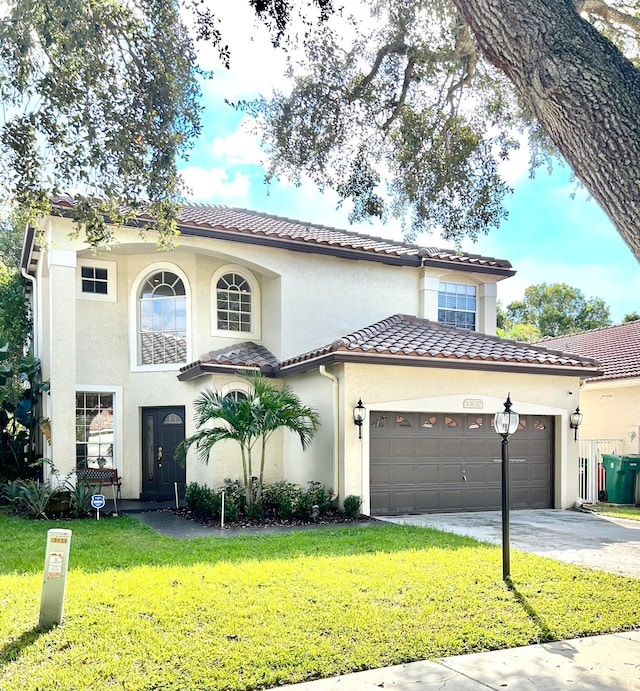 mediterranean / spanish-style home featuring a garage and a front yard