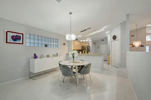 dining area with light tile patterned floors, vaulted ceiling, and a notable chandelier