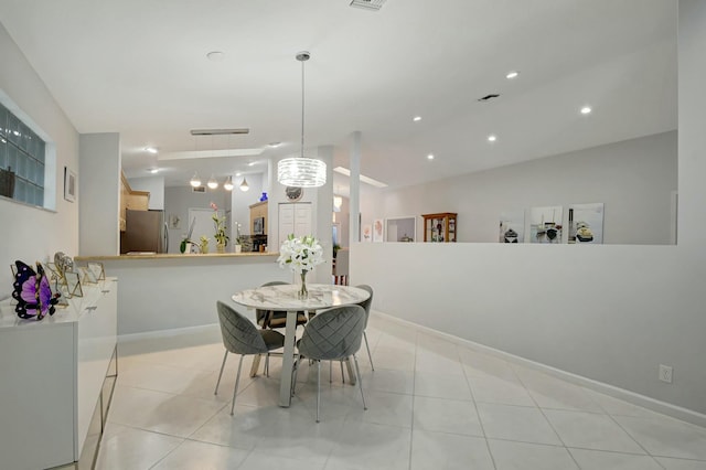 tiled dining space with a chandelier