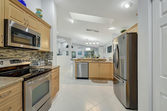 kitchen featuring hanging light fixtures, vaulted ceiling, decorative backsplash, light stone countertops, and stainless steel appliances