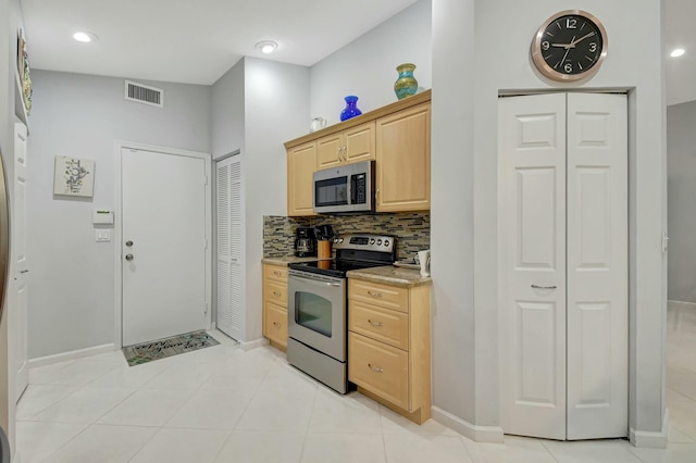 kitchen featuring light tile patterned floors, light brown cabinetry, appliances with stainless steel finishes, and tasteful backsplash