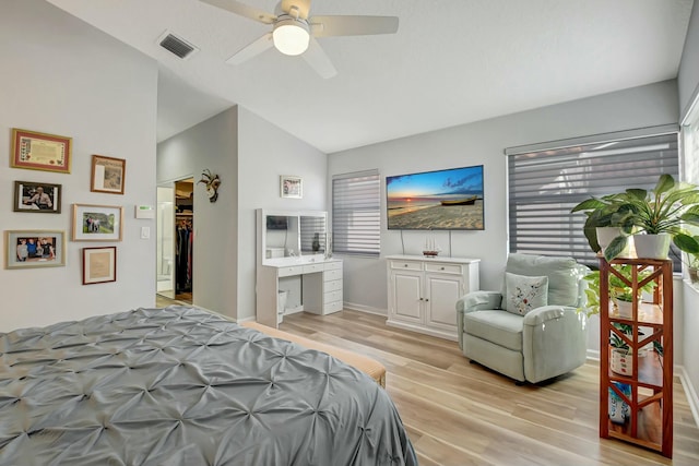 bedroom with multiple windows, ceiling fan, lofted ceiling, and light wood-type flooring