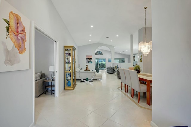 dining area featuring light tile patterned floors, an inviting chandelier, and lofted ceiling