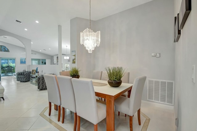 tiled dining space with vaulted ceiling and an inviting chandelier