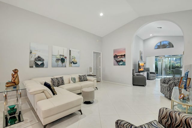 living room featuring light tile patterned floors and high vaulted ceiling