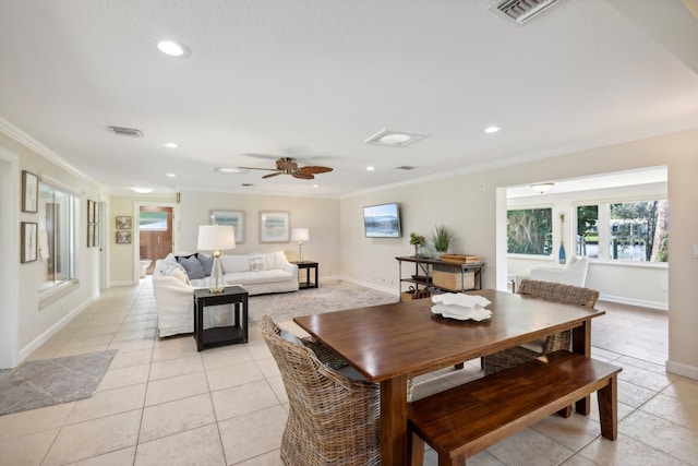 dining space with ceiling fan, light tile patterned floors, and ornamental molding