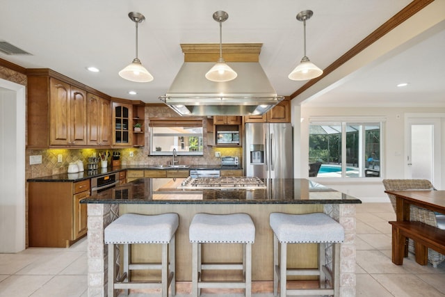 kitchen with plenty of natural light, a kitchen island, decorative backsplash, and stainless steel appliances