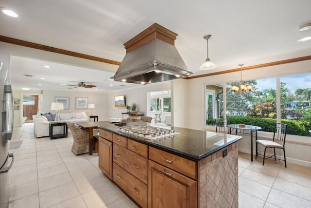 kitchen with pendant lighting, light tile patterned floors, ornamental molding, a kitchen island, and island exhaust hood