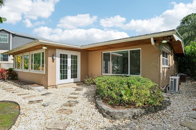 rear view of house with central AC and french doors