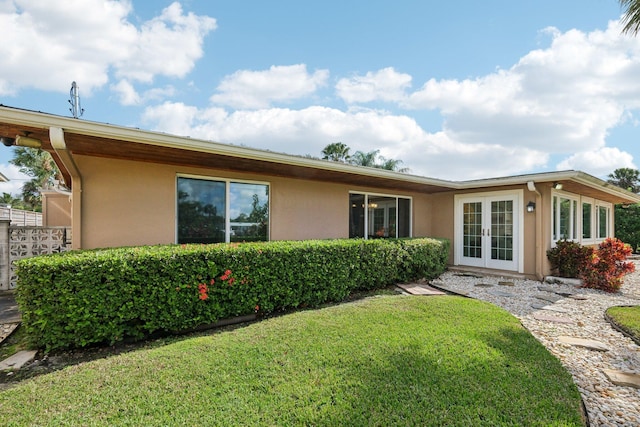 back of house with a lawn and french doors