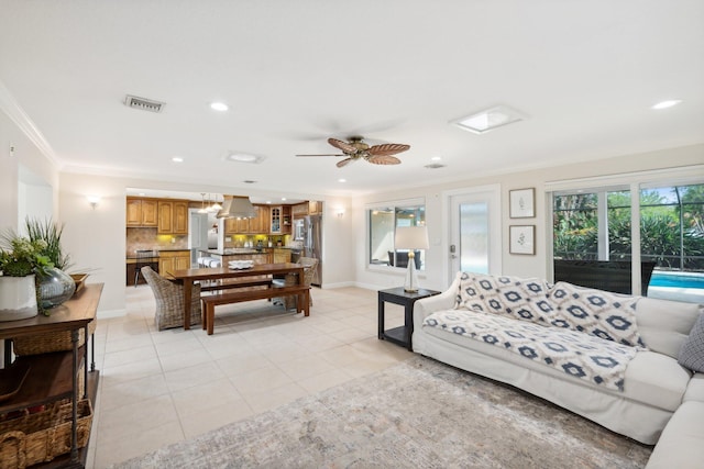 living room featuring ceiling fan, ornamental molding, and light tile patterned flooring