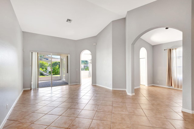 tiled spare room with lofted ceiling