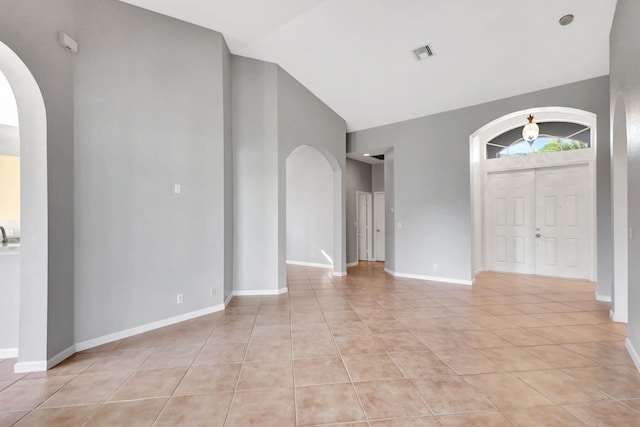 tiled foyer featuring vaulted ceiling