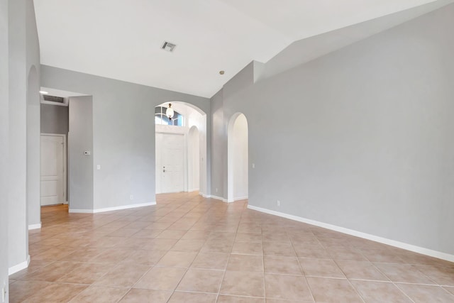 spare room with high vaulted ceiling and light tile patterned flooring