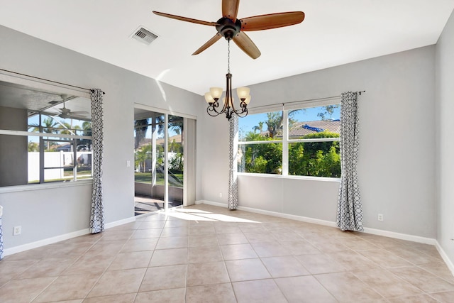 empty room featuring ceiling fan with notable chandelier and light tile patterned flooring