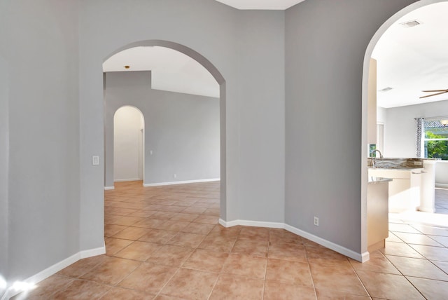 tiled empty room featuring sink and ceiling fan