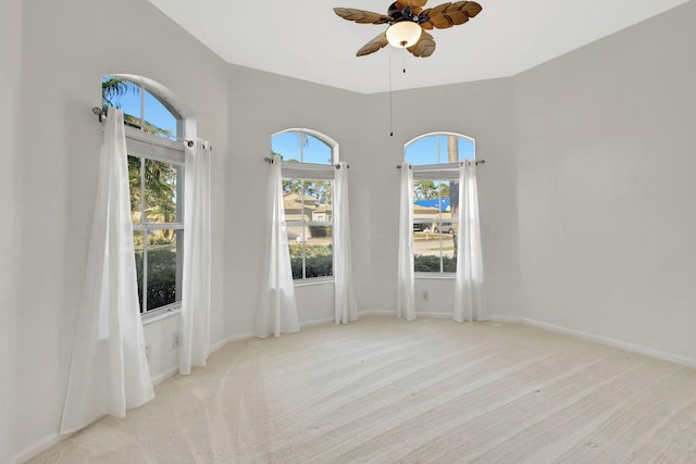 carpeted empty room with ceiling fan and a healthy amount of sunlight