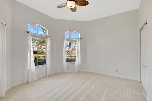 carpeted spare room with ceiling fan