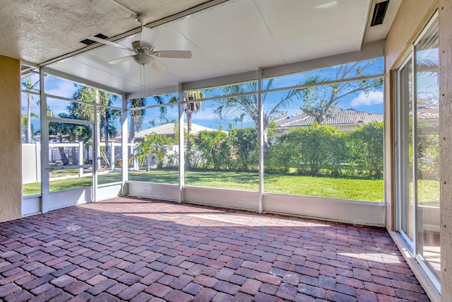 unfurnished sunroom with ceiling fan