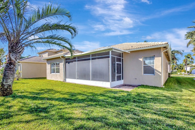 rear view of property with a yard and a sunroom