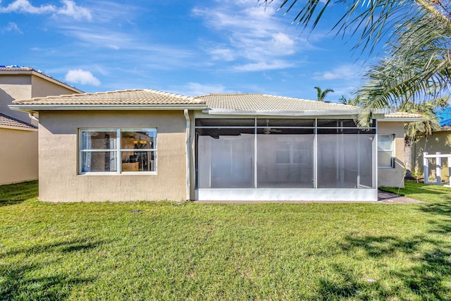 rear view of house with a yard and a sunroom