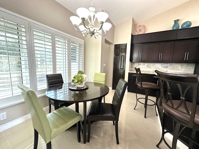 dining room featuring vaulted ceiling and an inviting chandelier