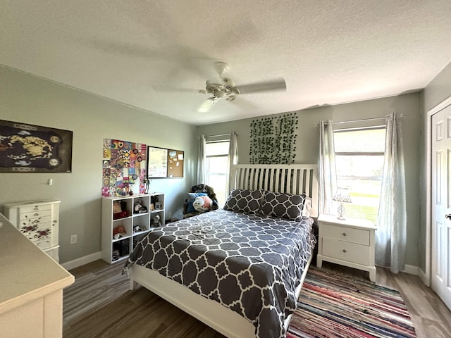 bedroom with wood-type flooring, multiple windows, and ceiling fan