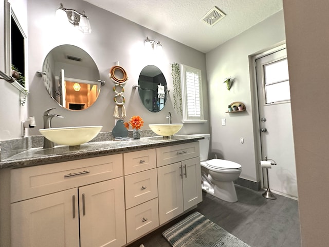 bathroom with vanity, a textured ceiling, and toilet