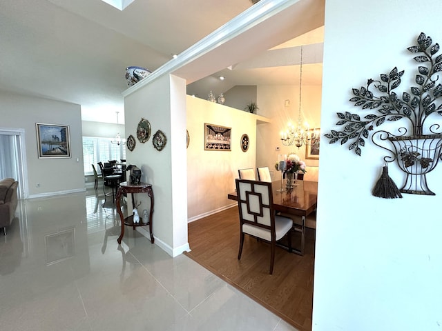 dining area featuring tile patterned floors, a notable chandelier, and lofted ceiling