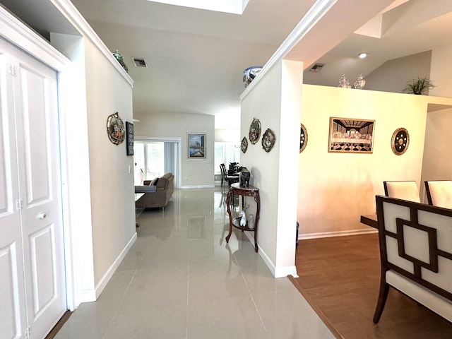 hall with tile patterned flooring and vaulted ceiling