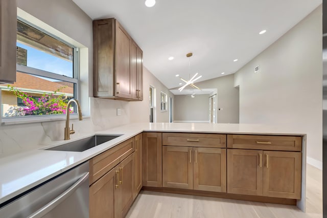 kitchen with dishwasher, sink, a notable chandelier, light hardwood / wood-style floors, and kitchen peninsula