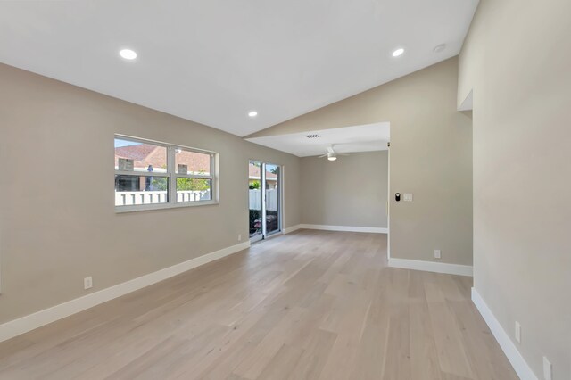 spare room featuring light hardwood / wood-style floors, vaulted ceiling, and ceiling fan