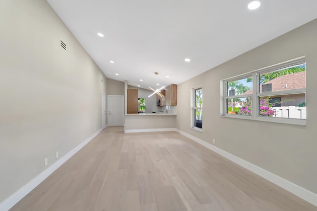 unfurnished living room with light hardwood / wood-style floors and lofted ceiling