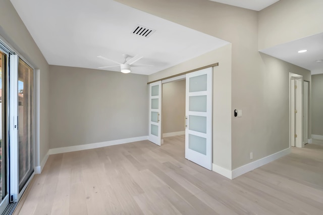 empty room with ceiling fan and light hardwood / wood-style floors