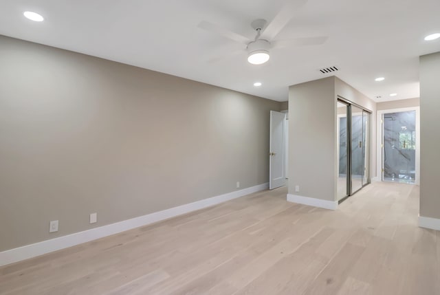 empty room with ceiling fan and light hardwood / wood-style flooring