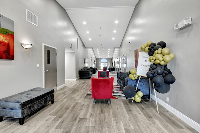 living room featuring high vaulted ceiling and light hardwood / wood-style floors