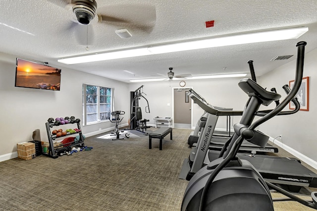 exercise area featuring ceiling fan, carpet floors, and a textured ceiling