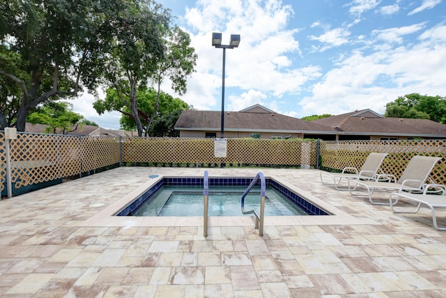 view of swimming pool featuring a patio and a hot tub