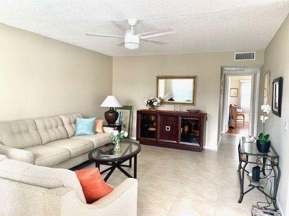 living room with a textured ceiling and ceiling fan