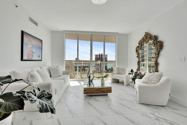 living area with marble finish floor, visible vents, expansive windows, and baseboards