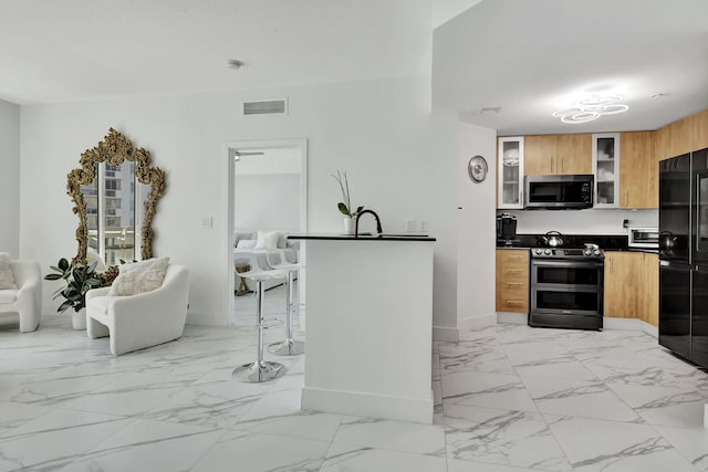 kitchen with appliances with stainless steel finishes, dark countertops, baseboards, visible vents, and modern cabinets