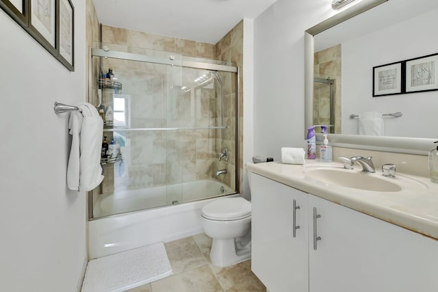 full bathroom with tile patterned floors, vanity, toilet, and enclosed tub / shower combo