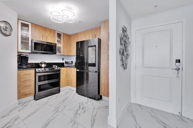 kitchen with baseboards, glass insert cabinets, appliances with stainless steel finishes, and marble finish floor