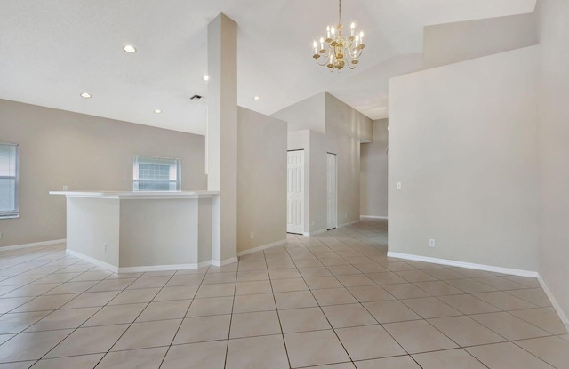 spare room featuring an inviting chandelier, lofted ceiling, and light tile patterned flooring